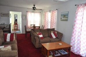 Una sala de estar con sofá, una mesa de centro y una zona de comedor con mesa y sillas.