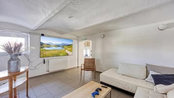 A living room with a television, a sofa, a coffee table, and a chair.