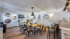 A dining area with a wooden table, black chairs, and a hanging light fixture. - Hedonia Estate /w Sauna and Jacuzzi Near Varazdin (Petrijanec)