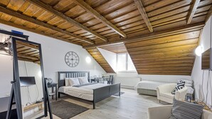 A bedroom with a sloped ceiling, a bed, a chair, a desk, and a mirror. - Hedonia Estate /w Sauna and Jacuzzi Near Varazdin (Petrijanec)