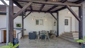 An outdoor patio area with a covered seating area, a staircase leading to an upper level, and potted plants. - Hedonia Estate /w Sauna and Jacuzzi Near Varazdin (Petrijanec)
