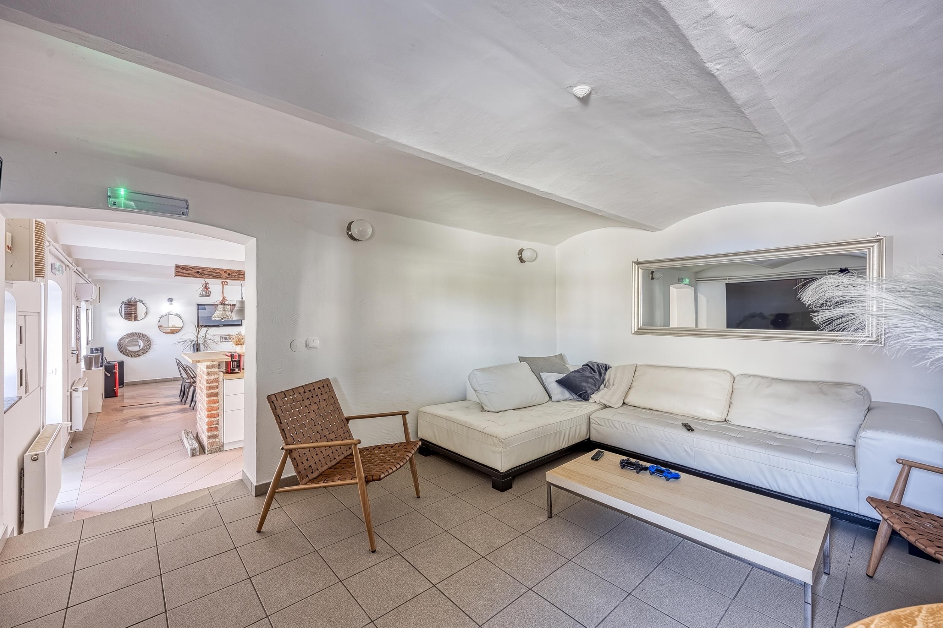 A modern living room with a sofa, a chair, a coffee table, and a TV.