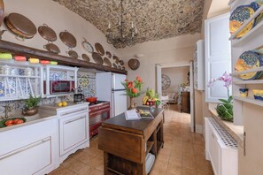 Una cocina equipada con estufa, microondas y diferentes utensilios.