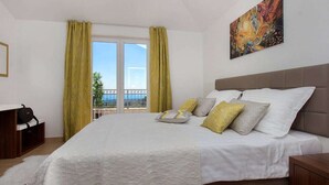 Un cuarto de hotel con una cama grande, un cuadro en la pared y vistas por la ventana.