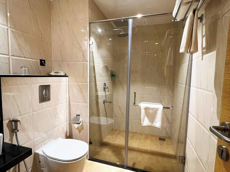 Un baño moderno con ducha envuelta en vidrio, inodoro y lavabo.