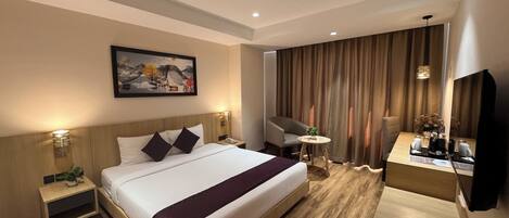 A hotel room with a large bed, bedside tables, a desk with a chair, a TV, and a painting on the wall.