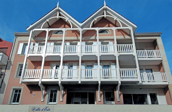 A multi-story hotel with balconies on each floor, a flat roof, and a sign indicating it is a hotel.