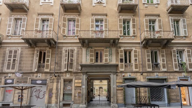 A historic building with multiple balconies, a central entrance, and outdoor seating area. - Carlo Alberto House by Wonderful Italy (Torino)