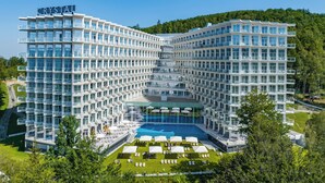 Un hôtel moderne doté d’un design modulaire unique, avec de nombreux balcons et une piscine centrale.