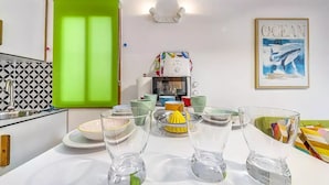 A modern kitchen with a green window, a coffee machine, and various kitchenware.