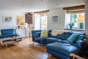Relax in this inviting living room with a sofa, coffee table, and floor-to-ceiling window offering a view of the outdoors.