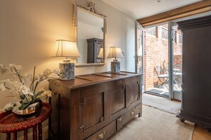 Bathroom features a vanity with a large mirror, two lamps, and a vase with orchids.