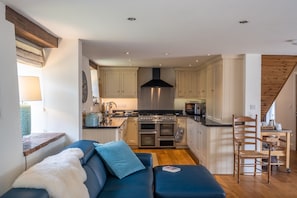 Enjoy cooking in the kitchen with a central island, double oven, and microwave, adjacent to a cozy seating area.