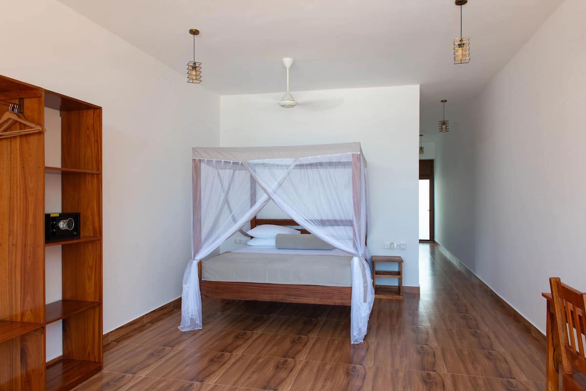 Un dormitorio con una cama de madera, un armario de madera y una mesita de noche.