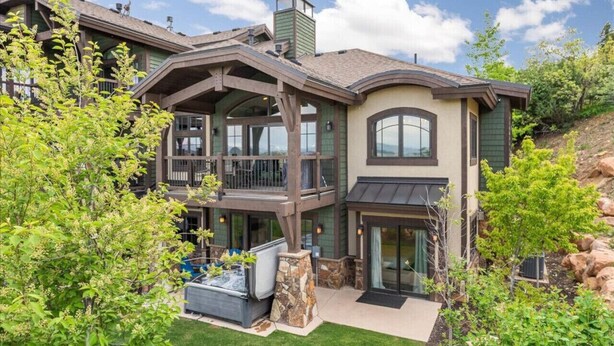 A two-story house with a balcony, a hot tub, and a stone fireplace. - Perfect location! Come and see (Park City)