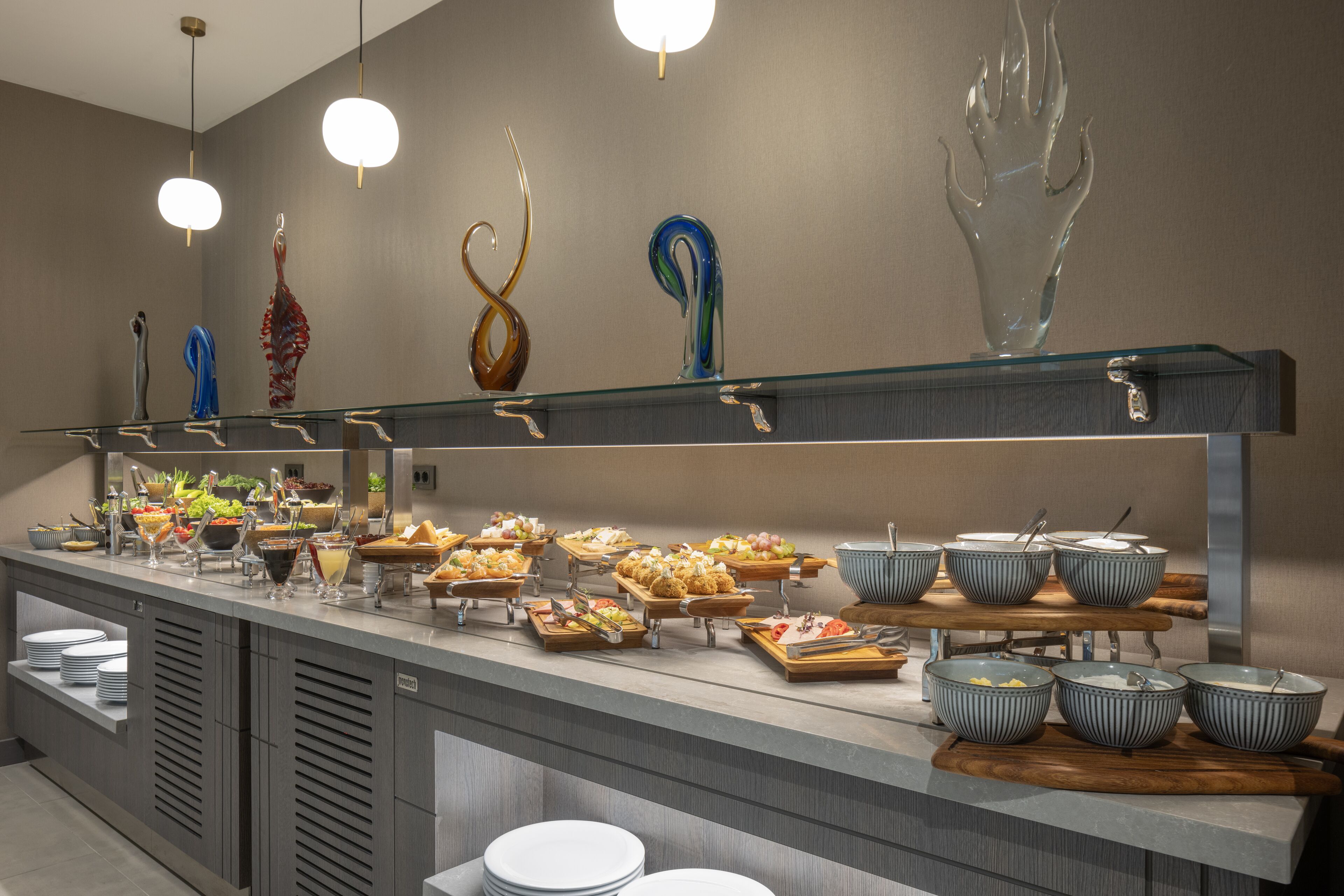 A buffet setup with various food items and glassware on display.