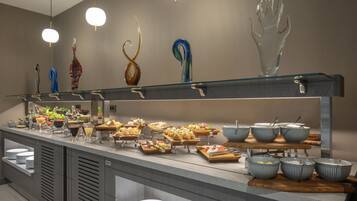 A buffet setup with various food items and glassware on display.