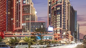 A tall hotel with a curved facade and illuminated signage. - Ramada Plaza By Wyndham Batumi (Batumi)