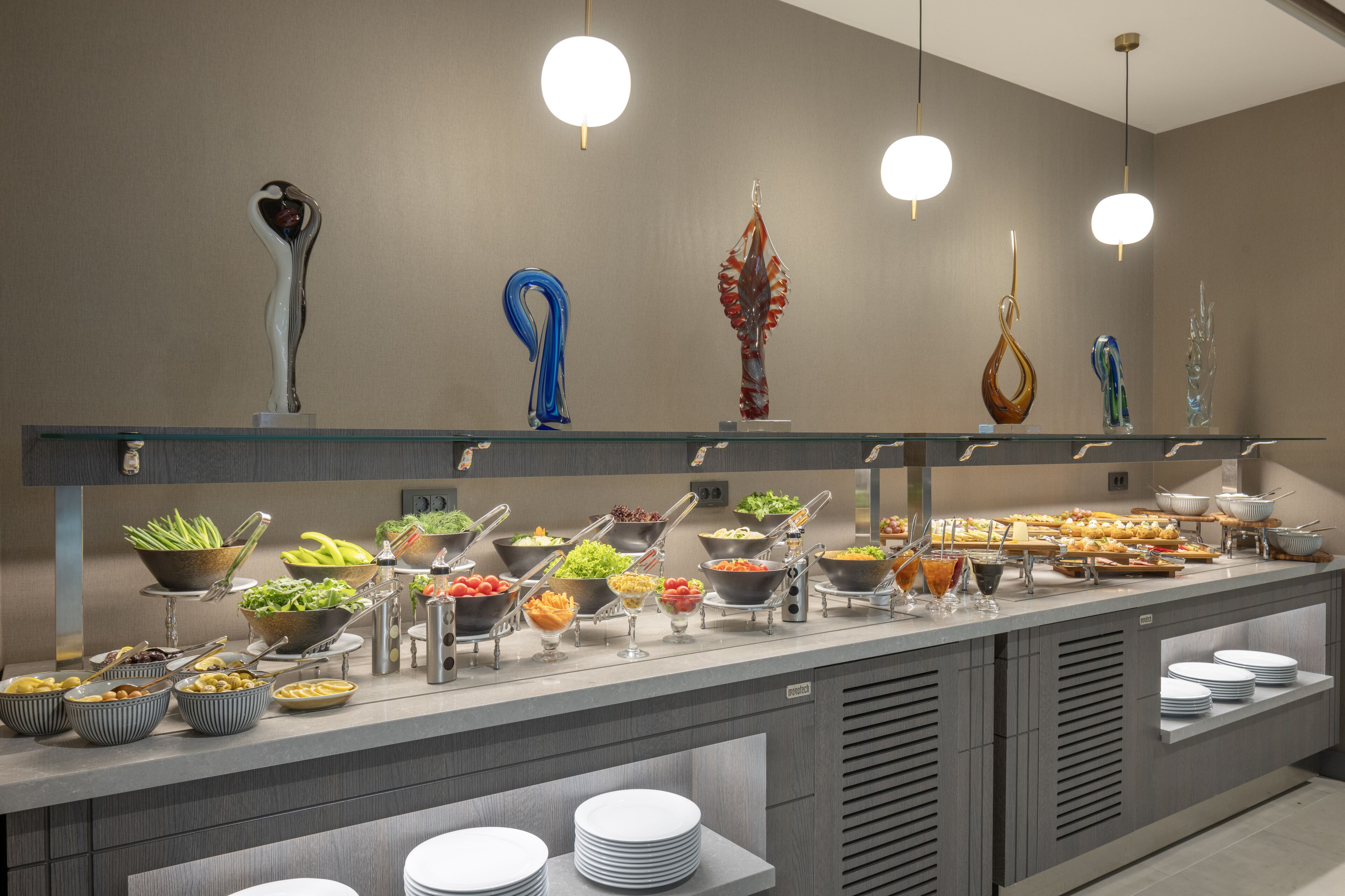 A buffet setup with various food items and decorative glassware on display.