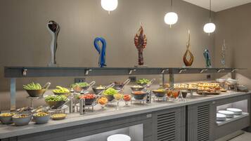 A buffet setup with various food items and decorative glassware on display.