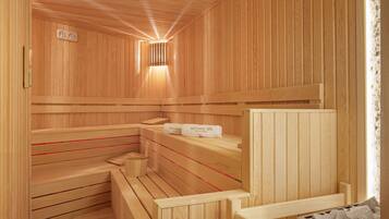 A wooden sauna with benches and a bench seat, a towel rack, and a wall-mounted heater.