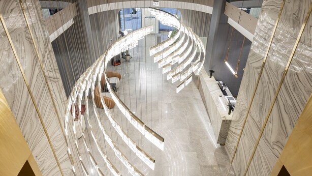 A modern interior with a curved ceiling and marble walls. - Ramada Plaza By Wyndham Batumi (Batumi)