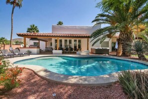 A modern house with a swimming pool, outdoor seating, and palm trees. - Serene Home | Heated Pool & Games (Phoenix)
