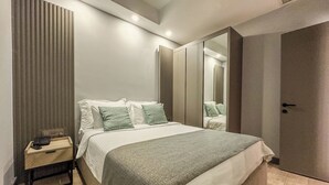 Een moderne slaapkamer met een bed, nachtkastje en een kledingkast.