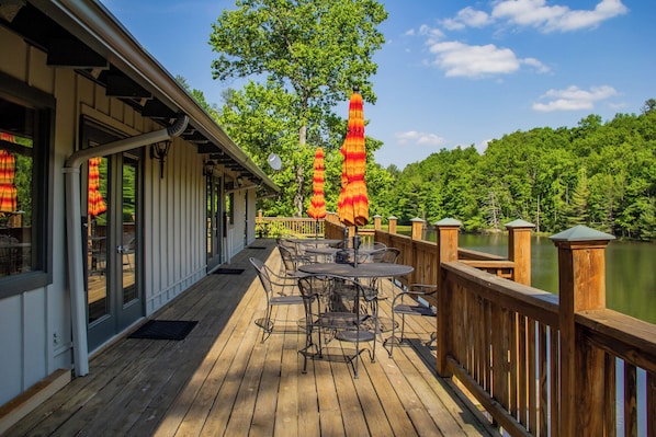 Une terrasse en bois avec des sièges extérieurs et une vue sur un lac.