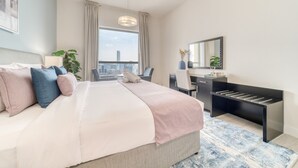 A modern hotel room with a large bed, a desk, a chair, a mirror, and a view of the city.