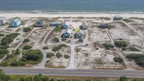 An aerial view of a coastal property with multiple buildings, a road, and a beach in the background. - La De Da | 3BR/2BA Fort Morgan Home | Sleeps 8 | Gulf Views & Bunkroom Fun (Gulf Shores)