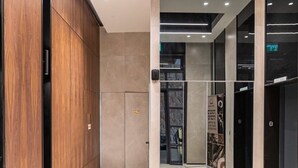 A modern interior with wooden paneling, a glass elevator, and recessed ceiling lighting. - Luxury 3 BDR  In The Heart Of Jerusalem By Isrentals (Jerusalem)
