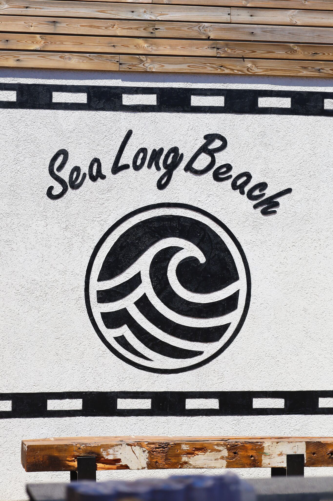 A wall with the text "Sea Long Beach" and a stylized wave logo.
