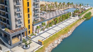 A modern hotel with a central courtyard, a pool area, and a beach view. - Ayvalık Sea Long (Ayvalik)