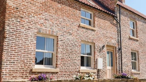 A two-story brick building with multiple windows, a stone foundation, and a tiled roof. - The Workshop (Northallerton)