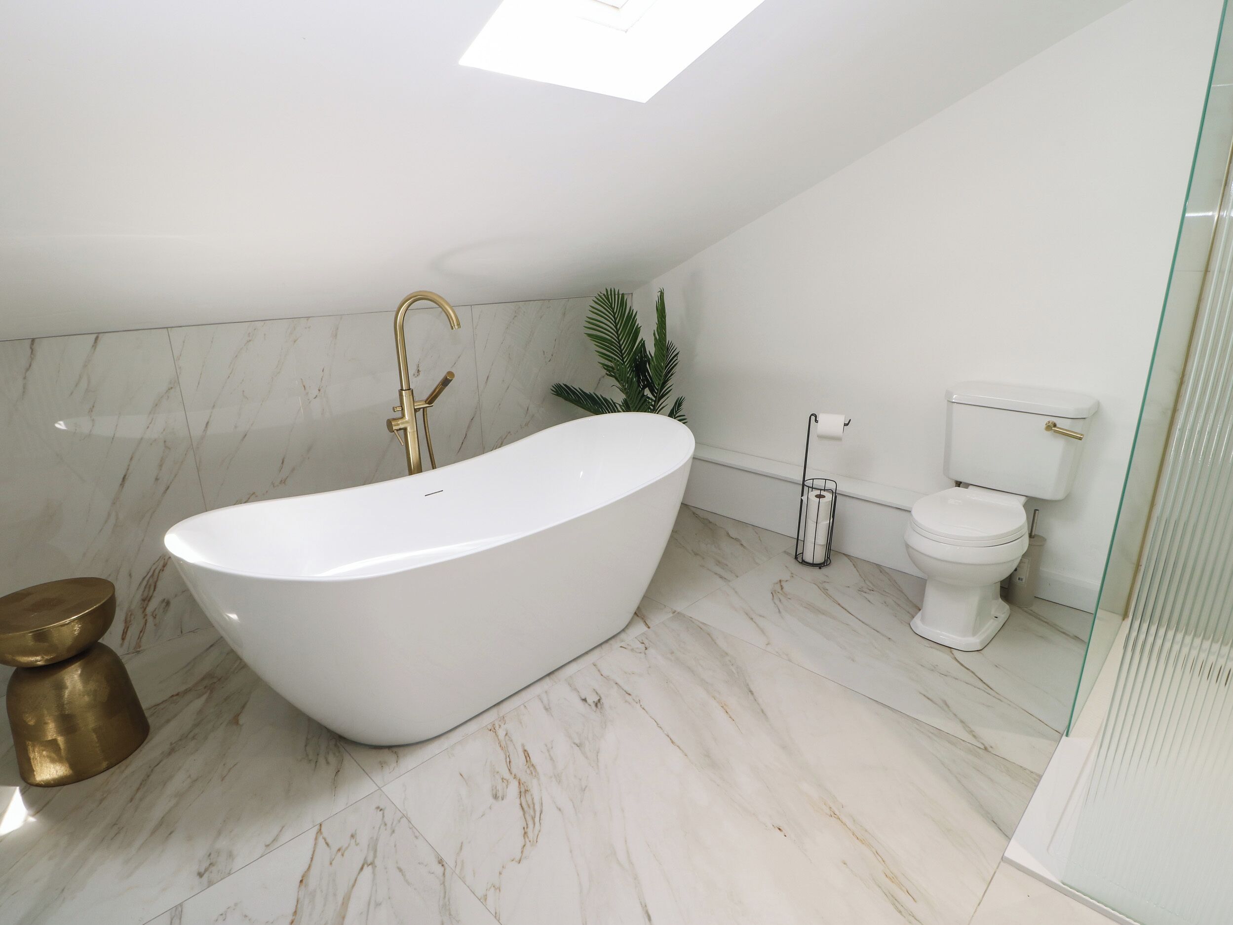 A modern bathroom with a freestanding bathtub, a toilet, and a shower area.