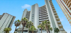 A high-rise building with multiple balconies and a 'Tidewater' sign, surrounded by palm trees. - Stunning Oceanfront Condo With Resort Amenities 3 Bedroom Condo by RedAwning (Orange Beach)