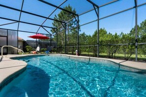 A swimming pool with a clear blue water, surrounded by a glass enclosure, and a red umbrella. - Last Minute Disney! Private Pool, Game Room & Themed Bedrooms. Book Now! #93821 (Orlando)