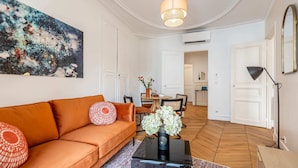 Een moderne woonkamer met een bank, een salontafel en een schilderij aan de muur.