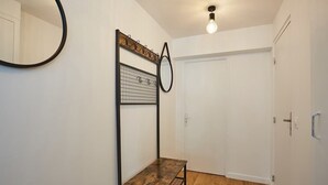 A small room with a wooden bench, a metal shelf with a mirror, and a door. - Sublime 3 bedrooms flat center of Paris Montmartre (Paris)