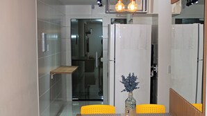 A modern dining area with a rectangular table, four yellow chairs, and a vase with flowers. - Casa Super Moderna (Cabo Frio)
