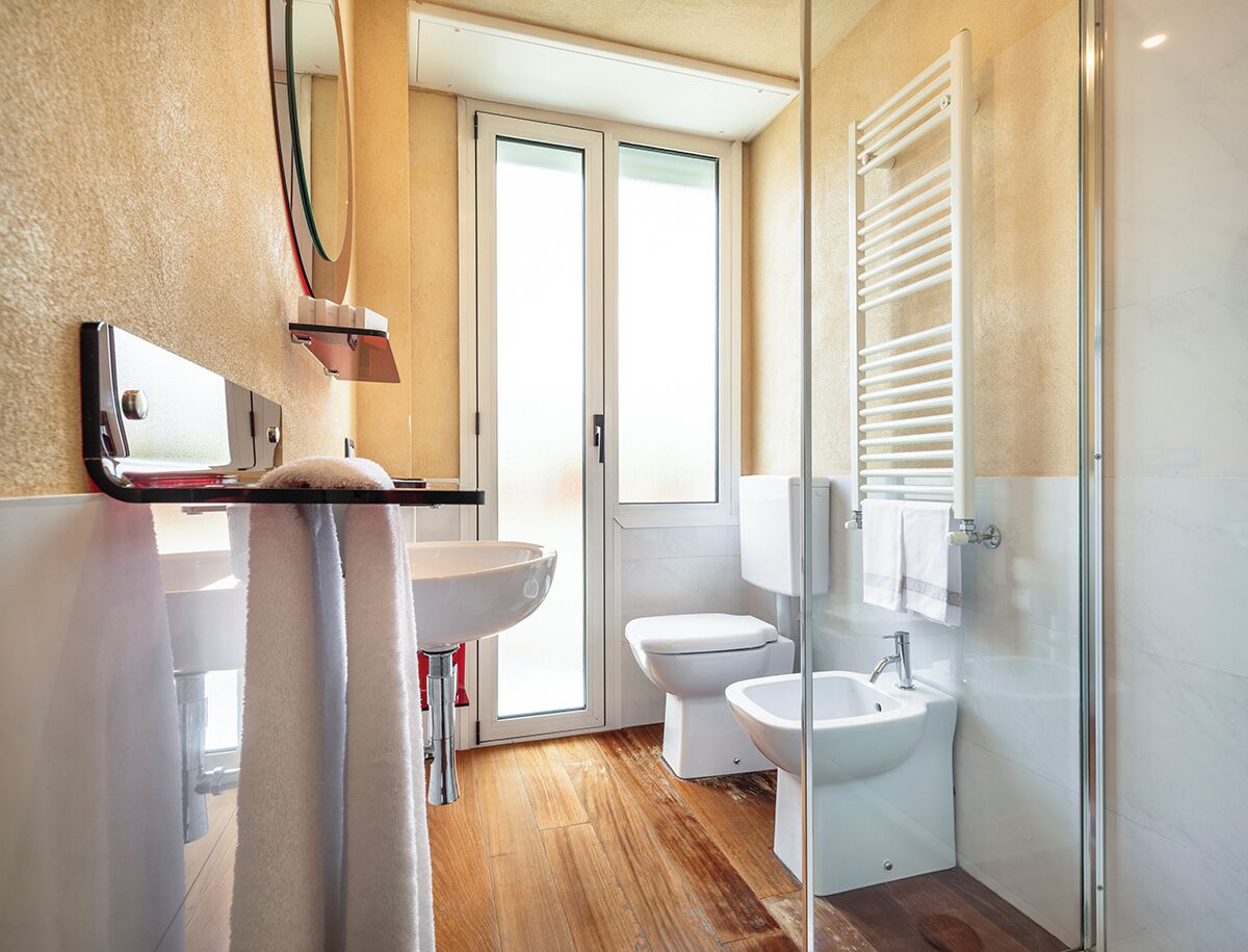 Un baño moderno con lavamanos, bidé, inodoro y ducha.