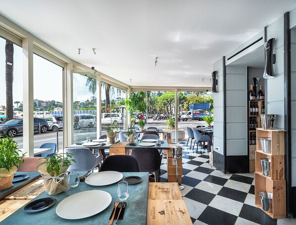 A restaurant with outdoor seating, checkered floor, and a view of the street. - Rosabianca Boutique Hotel (Rapallo)
