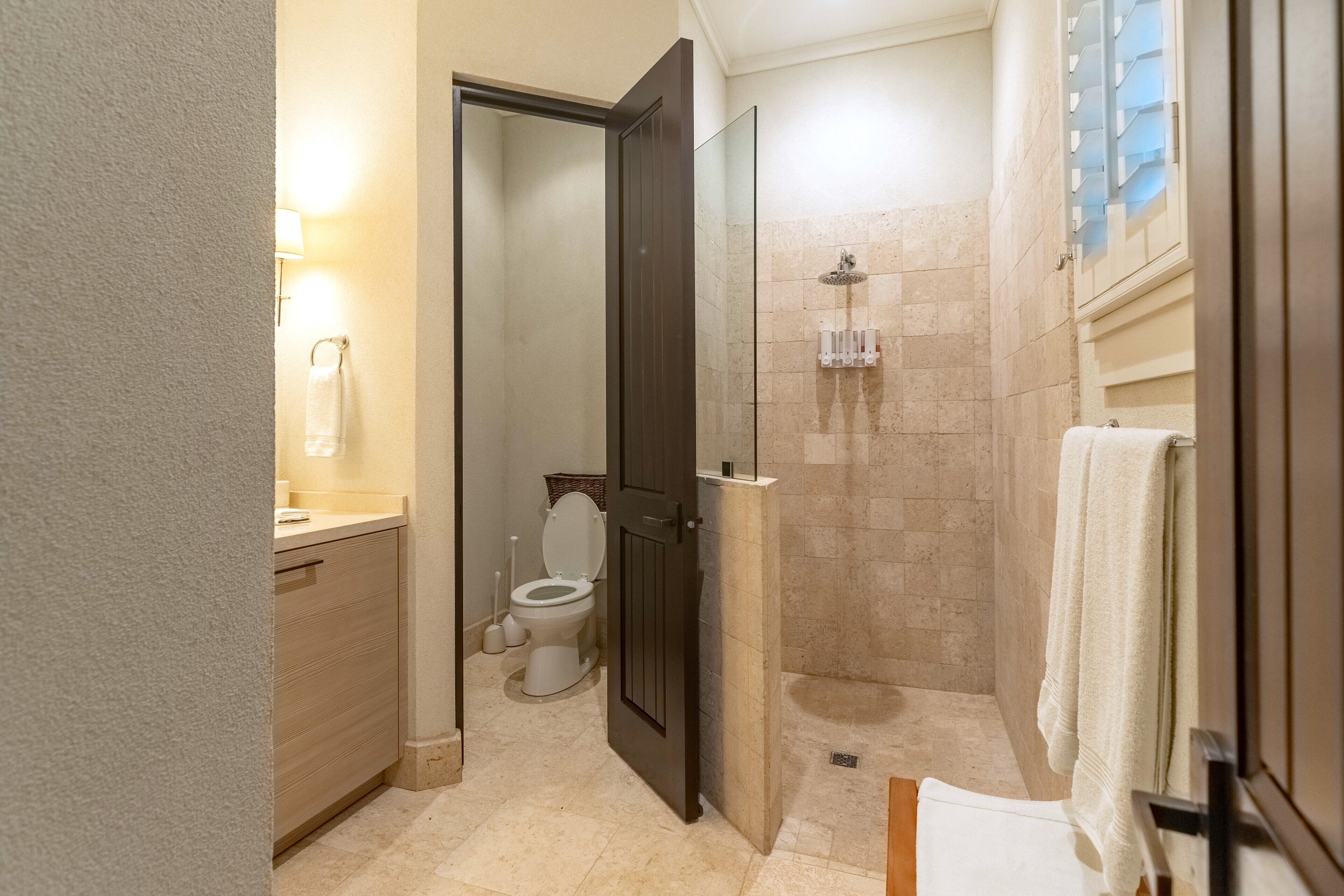 A bathroom with a shower, toilet, and sink.