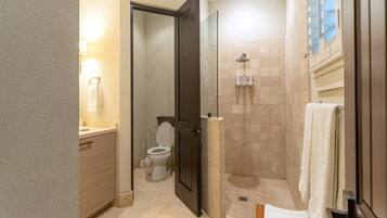 A bathroom with a shower, toilet, and sink.