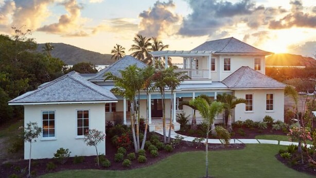 A two-story house with a covered porch and a well-maintained lawn.