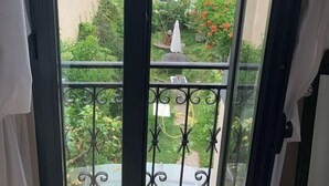 A balcony with a wrought iron railing overlooking a garden and neighboring buildings. - Loft Appart Proche Paris Chez Christine (Suresnes)