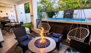 A patio with a fire pit, wicker furniture, and a pool. - Calle Principal 842 (Valle de Guadalupe)