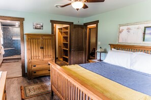 Une chambre à coucher avec un lit, une armoire en bois et un placard avec des étagères.