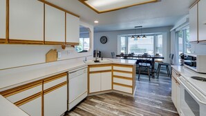 Eine moderne Küche mit weißen Schränken, Holzdetails und einer zentralen Kochinsel.